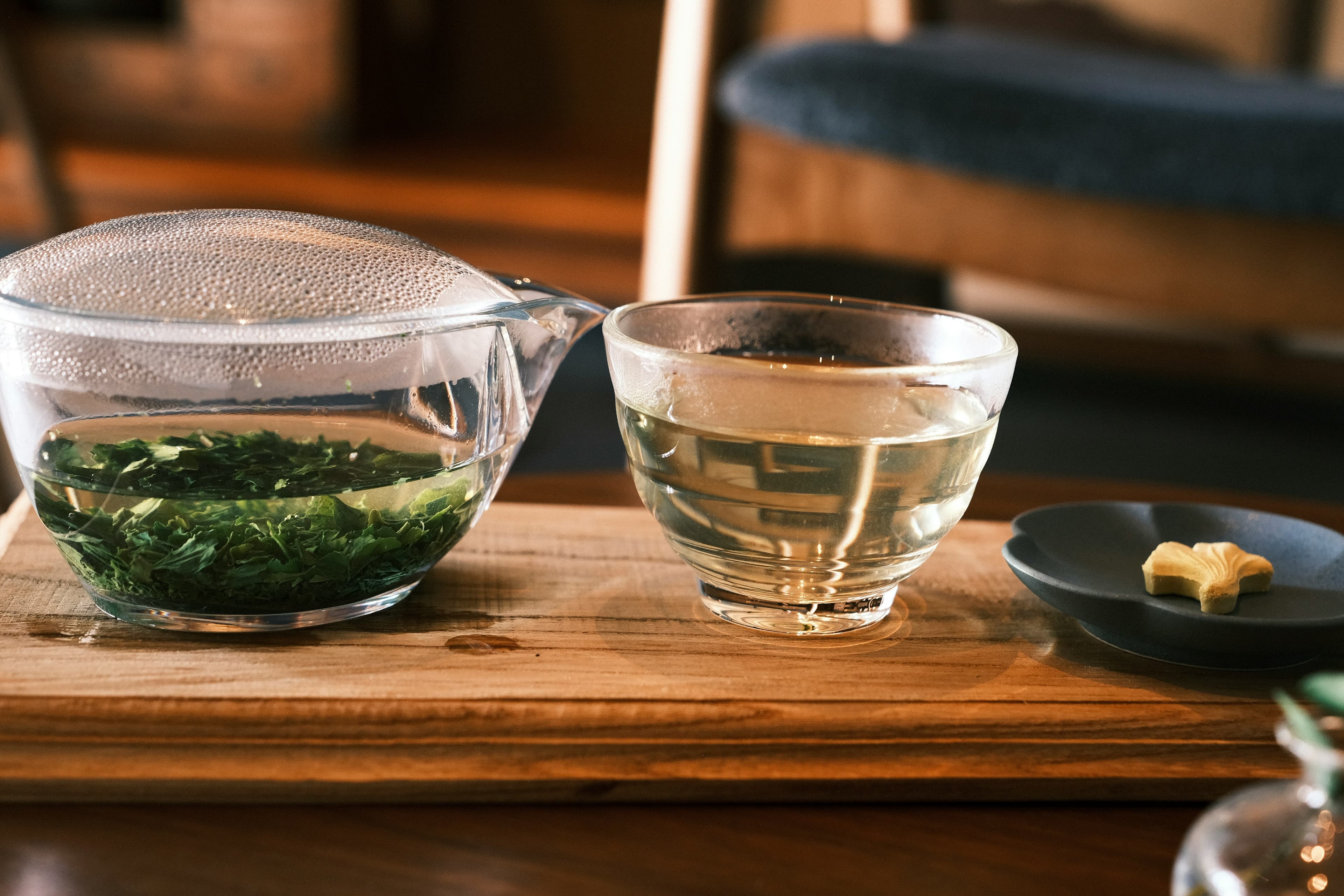 ガラスのポットで淹れた緑茶と木のトレイの湯呑み (※イメージ写真)