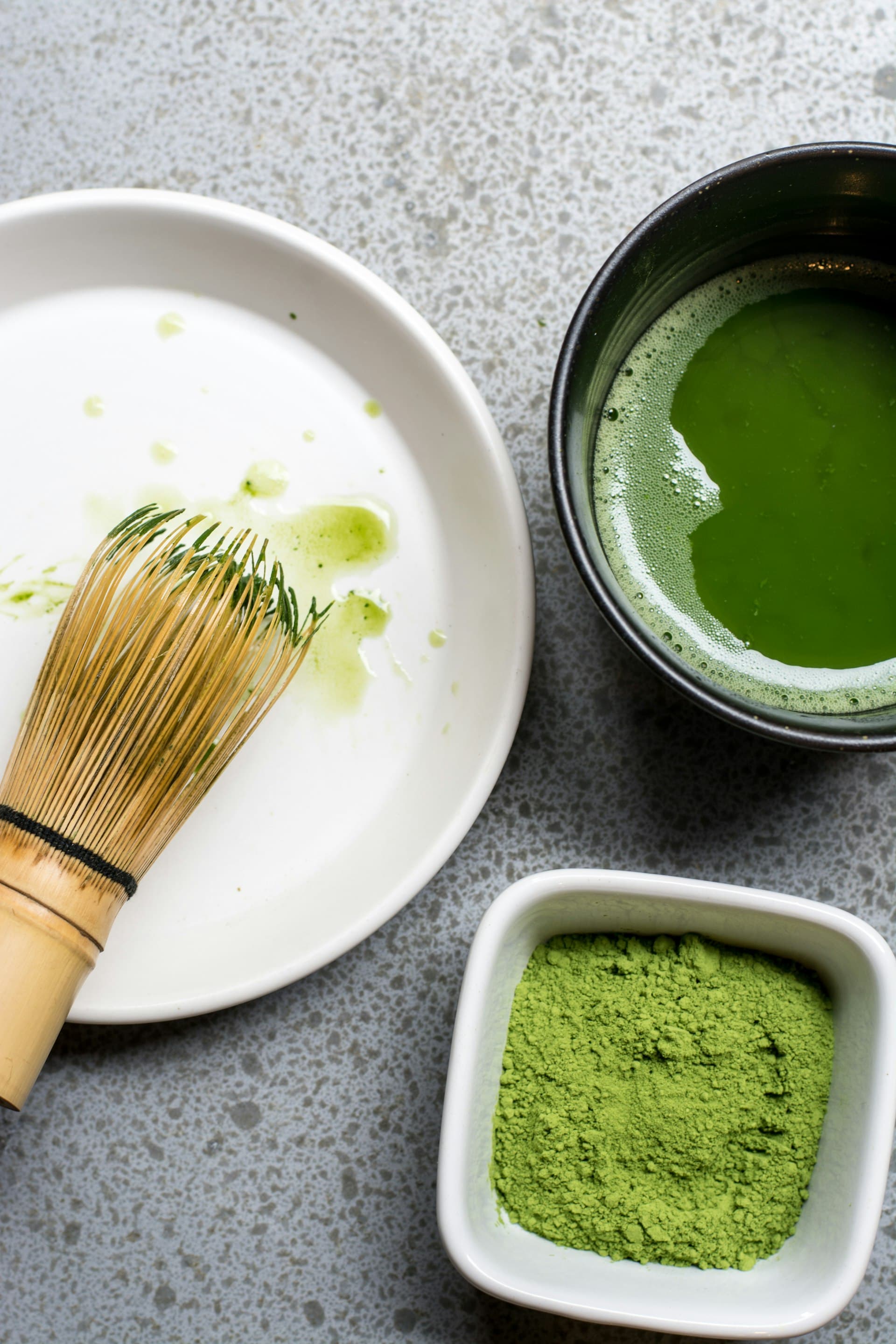 茶筅と抹茶碗、鮮やかな抹茶粉が並んだ俯瞰の一枚 (※イメージ写真)